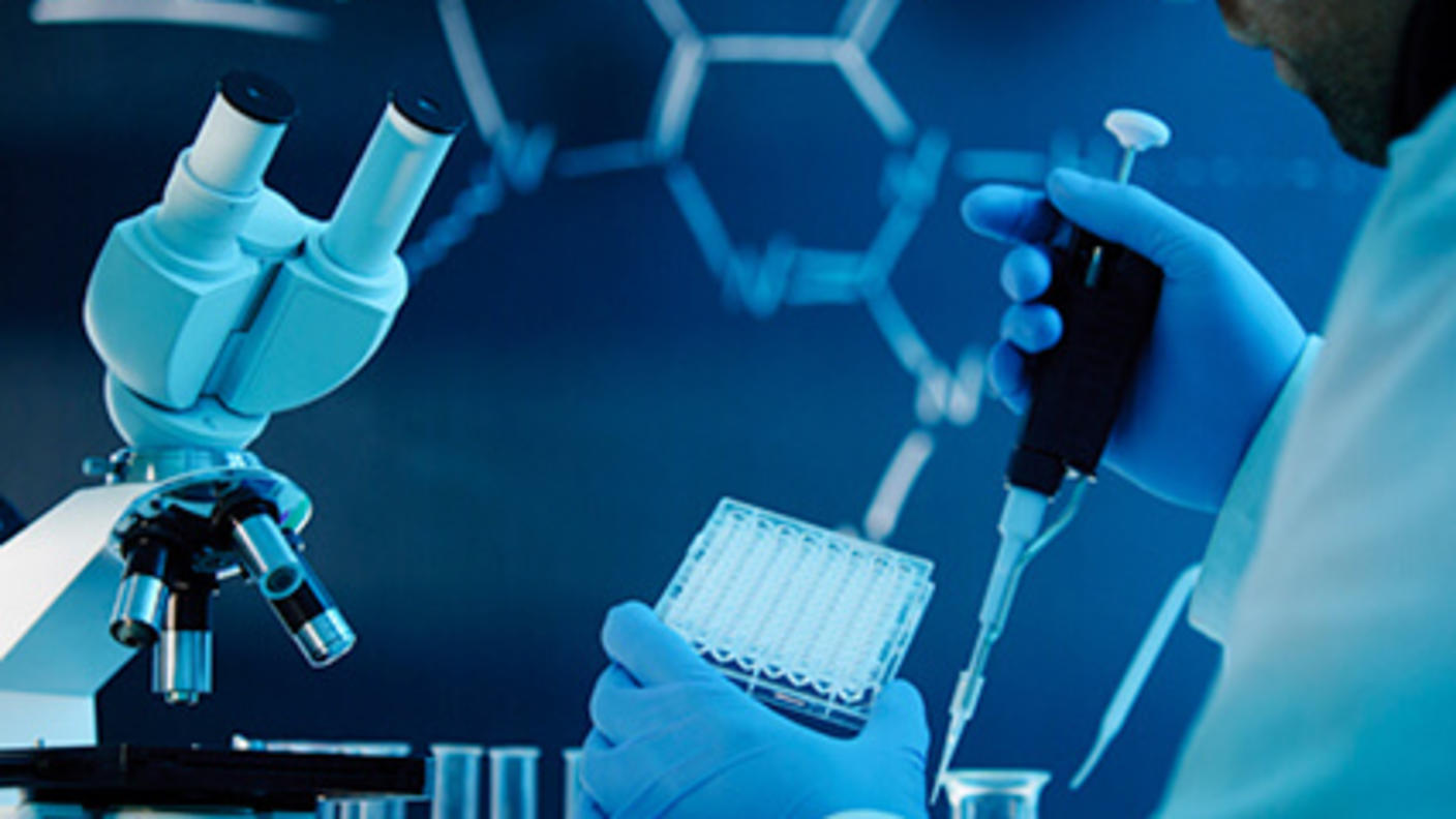 A male researcher using a pipette in a lab setting.