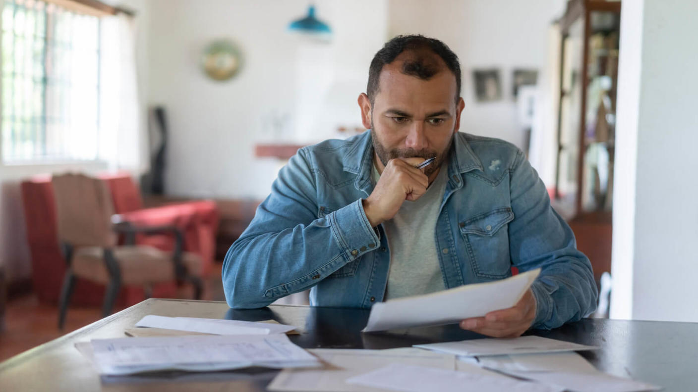 A man reviews medical bills with a look of concern on his face.