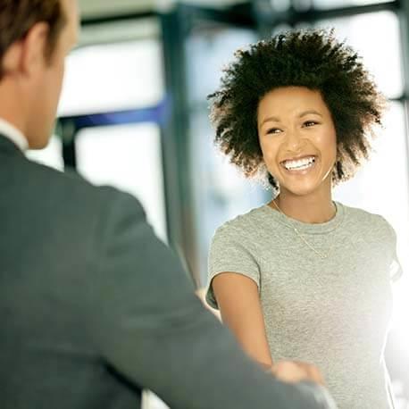 Professional woman shaking hands with a man in a business suit