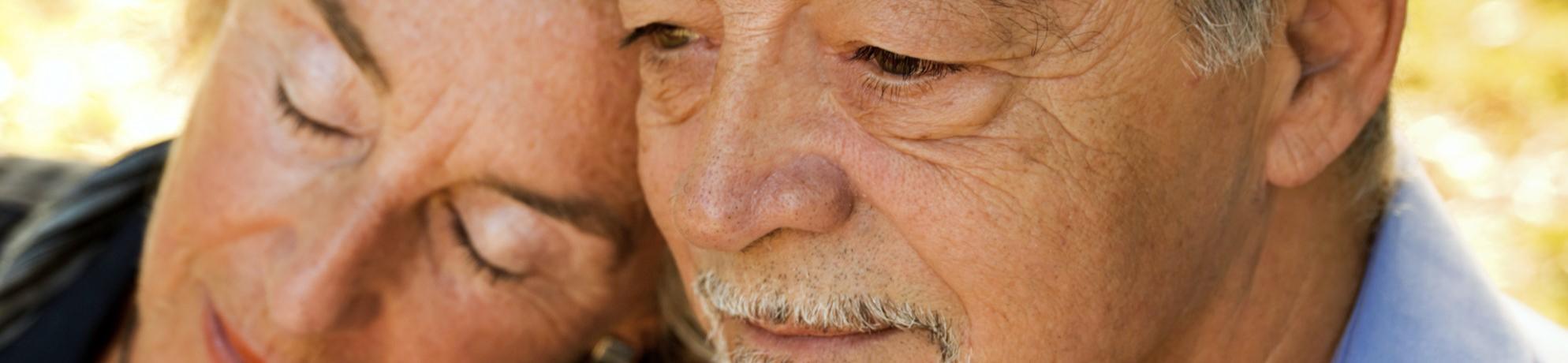 Una mujer mayor recostada en el hombro de un hombre mayor