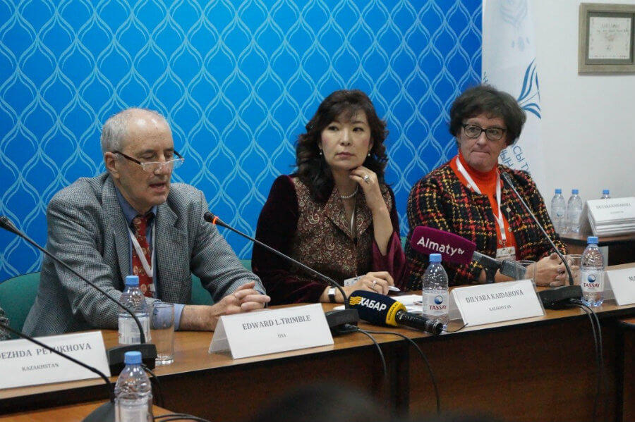 Photo of E. Trimble, D. Kaidarova, and M. Eiken at a press conference.
