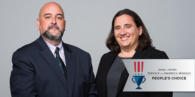 Jean-Claude Zenklusen, Ph.D., and Carolyn Hutter, Ph.D standing together for a picture. There is a banner overlaying the image in the bottom right corner that reads "Service to America Medals People's Choice"