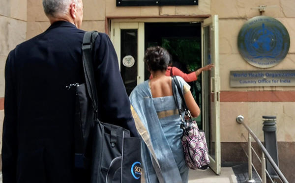 Rear view of two people entering the World Health Organization Country Office for India.