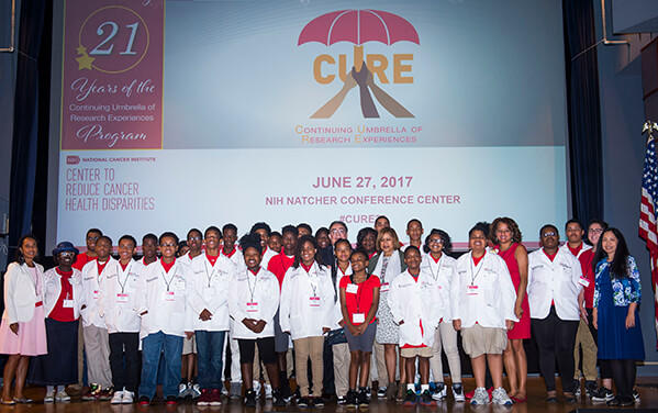 A group of scholars standing together on stage during a ceremony on June 27, 2017, smiling and posing for a photo.