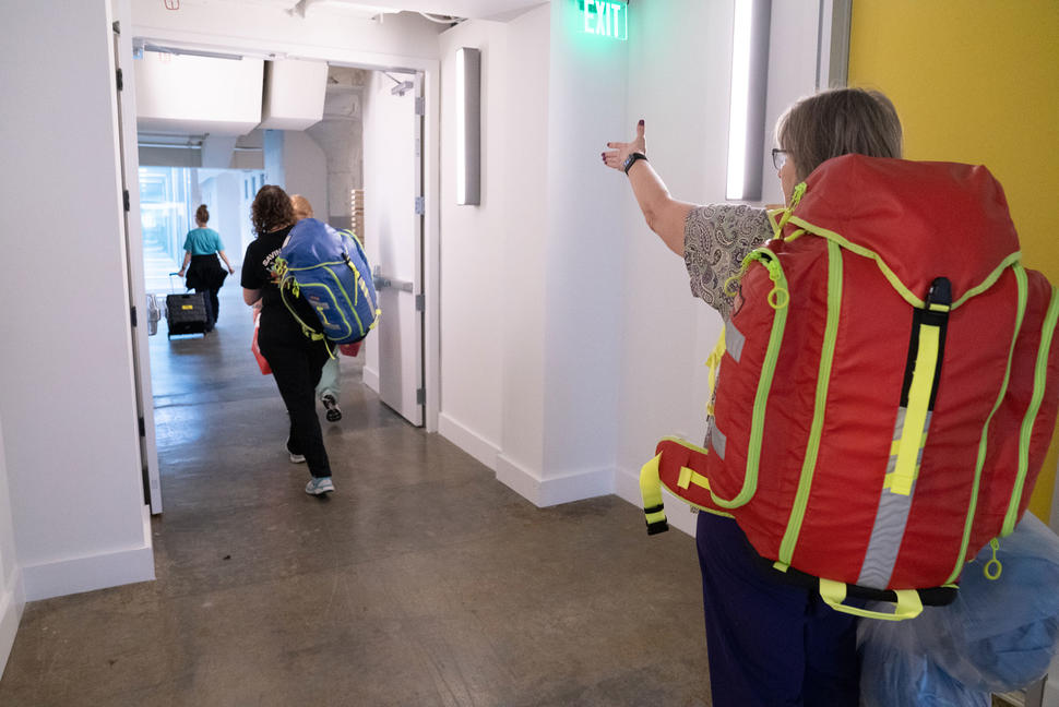 Three nurses at St. Jude wearing backpacks filled with medical supplies. 