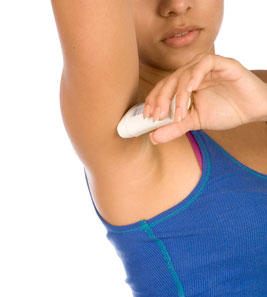Female applying deodorant under a raised arm.