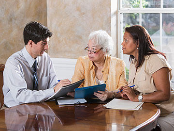 Older female and adult daughter meet with male advisor.
