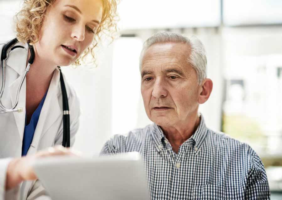A medical professional and patient reviewing information on paper. 