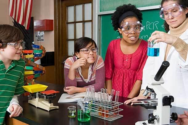 Science teacher conducting experiment with middle school students