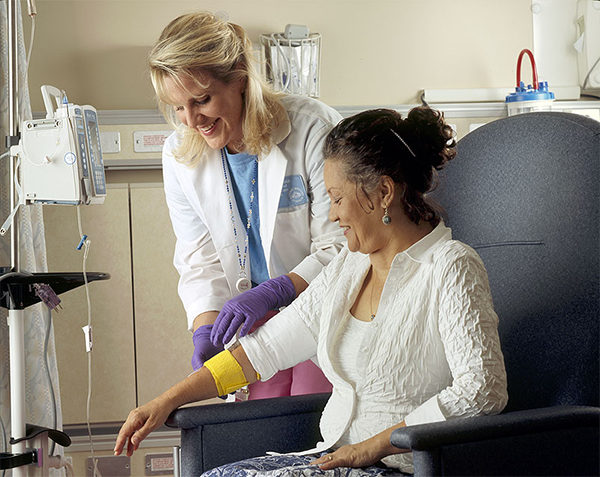 A medical professional bandaging a patient receiving IV chemotherapy.