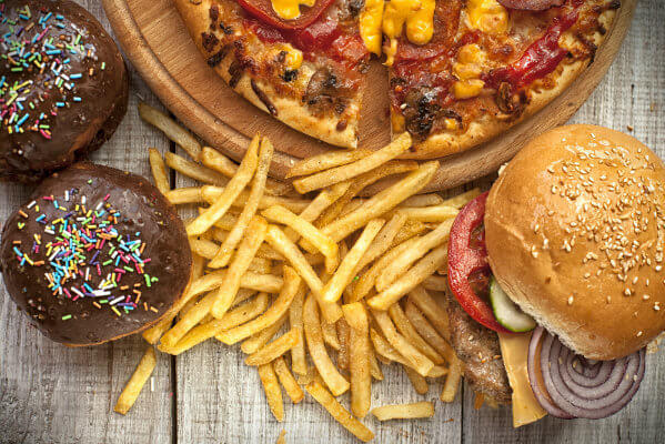Image of high fat foods including donuts, french fries, cheeseburger, and pizza.