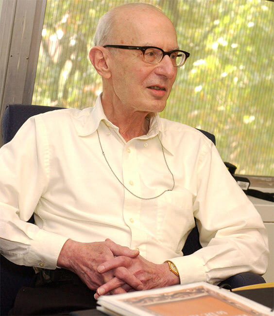 Alan Rabson, M.D. sitting in a desk chair in his office, engaged in a conversation