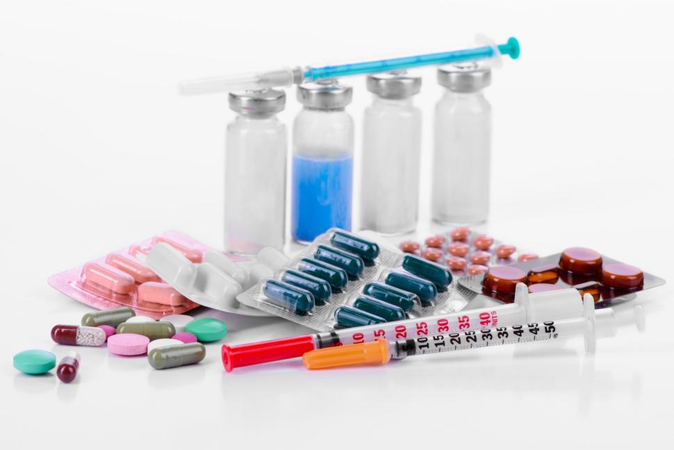 Medical supplies including vials, syringes, and various pills and capsules