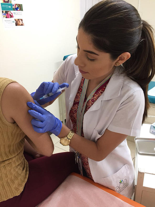 A nurse administering an HPV vaccine to a young woman.