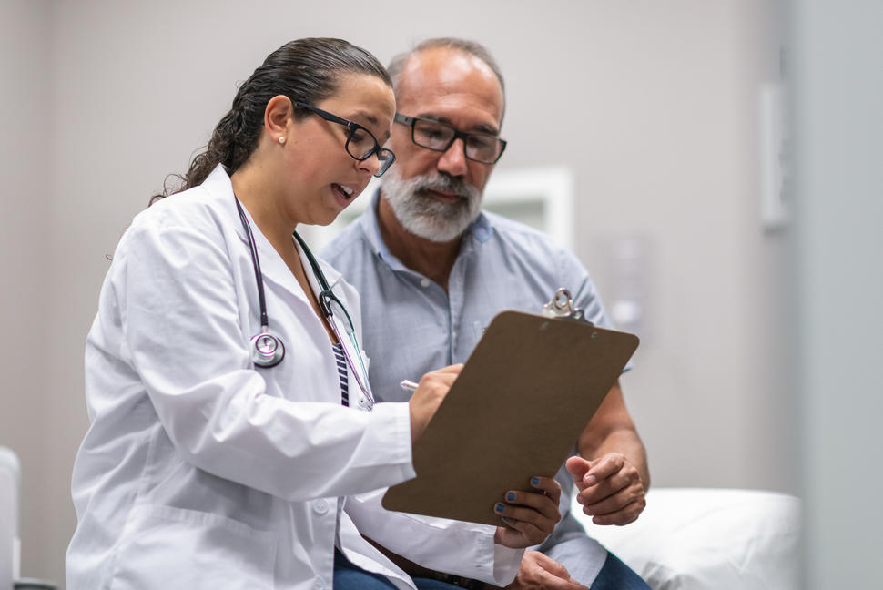 Una médica conversa con un paciente.