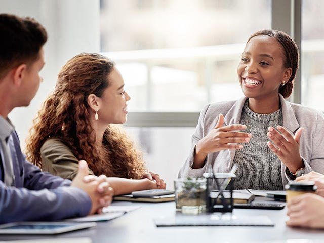 Group of colleagues discussing a topic around a table