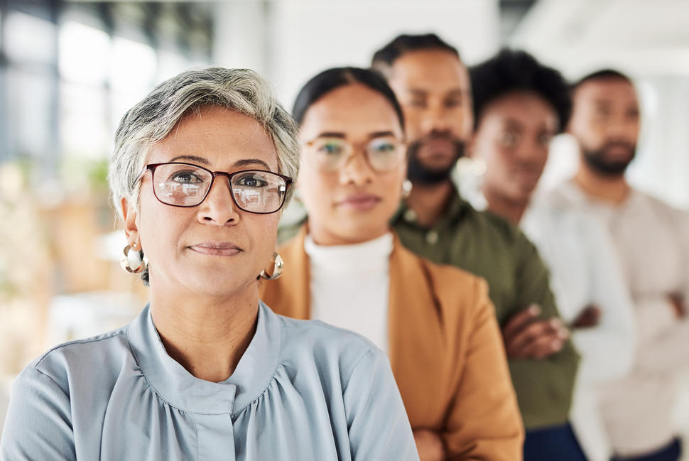  A group of diverse people are standing in a row.