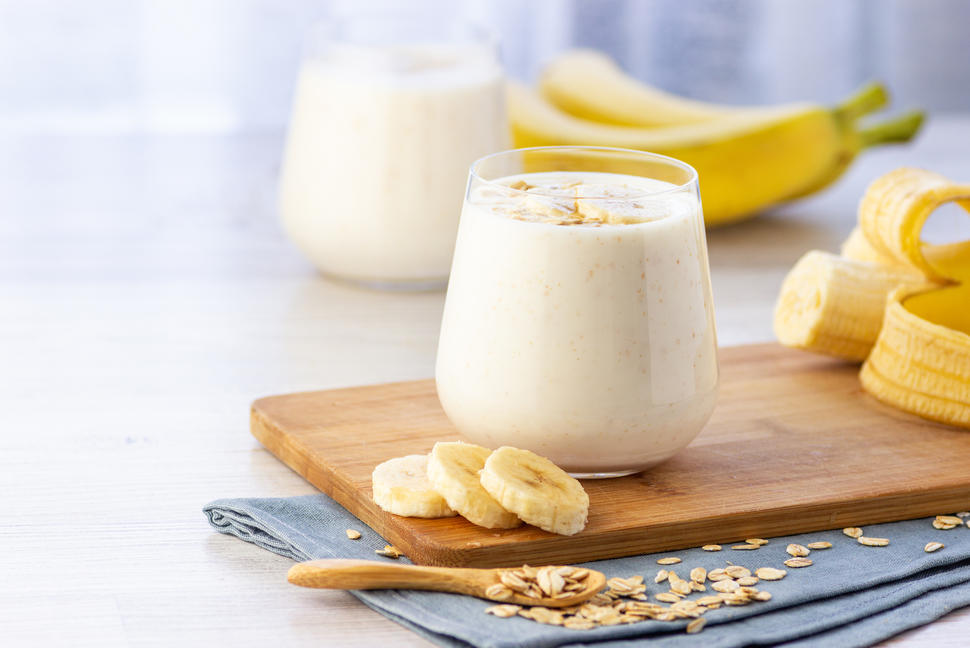 Vaso de vidrio que contiene avena preparada la noche anterior con unas rodajas de banana.  