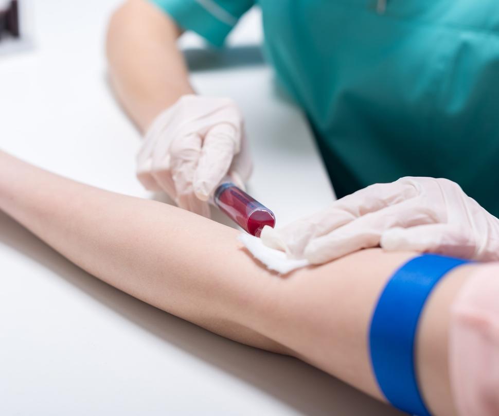 Un trabajador de salud extrae sangre del brazo de un paciente con una jeringa.