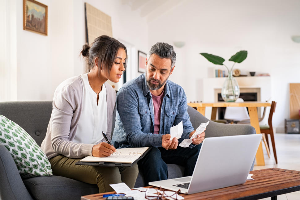 a man and woman looking at a computer and paperwork