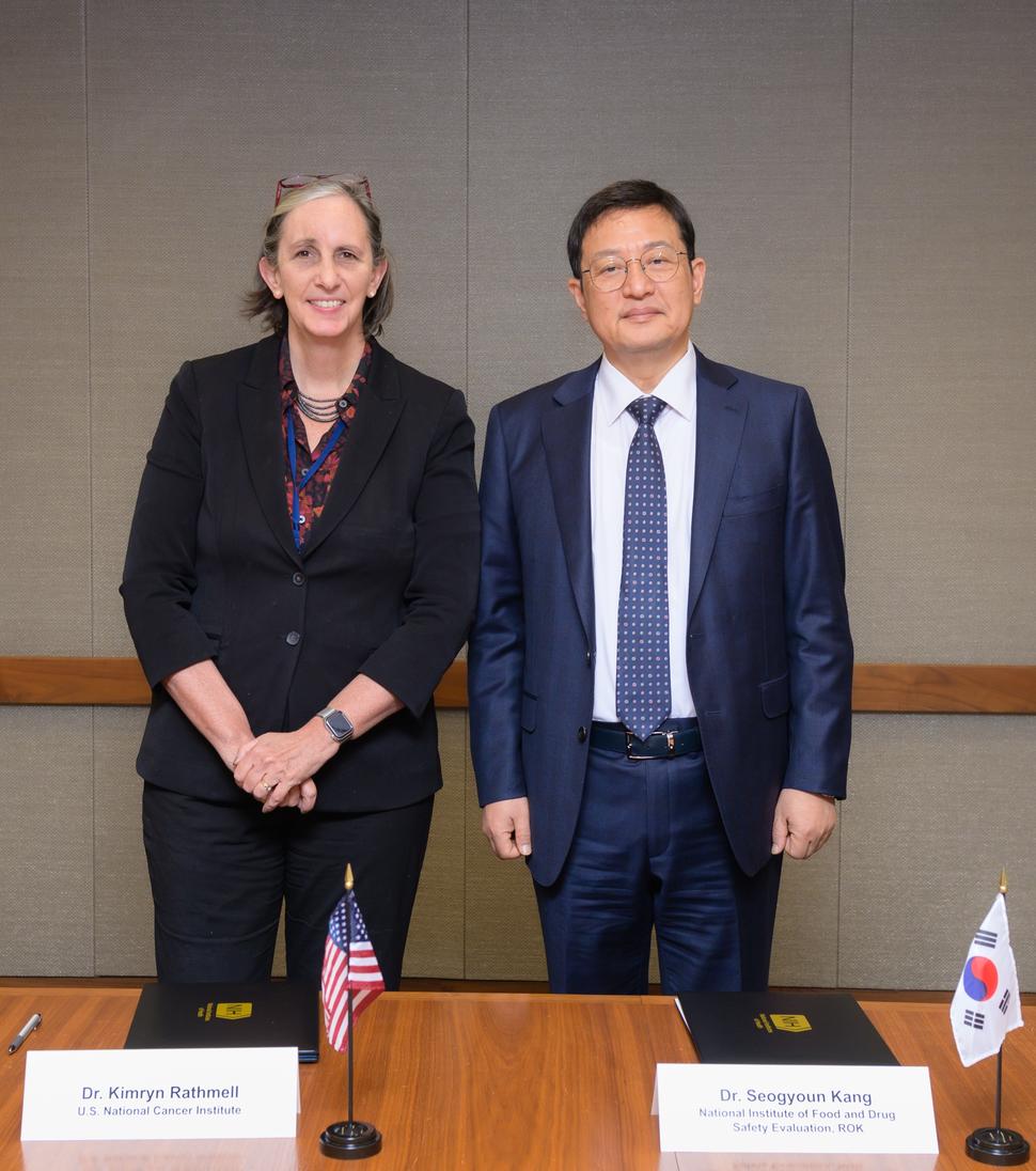 Dr. Kimryn Rathmell and Dr. Seogyoun Kang standing together in front a table.