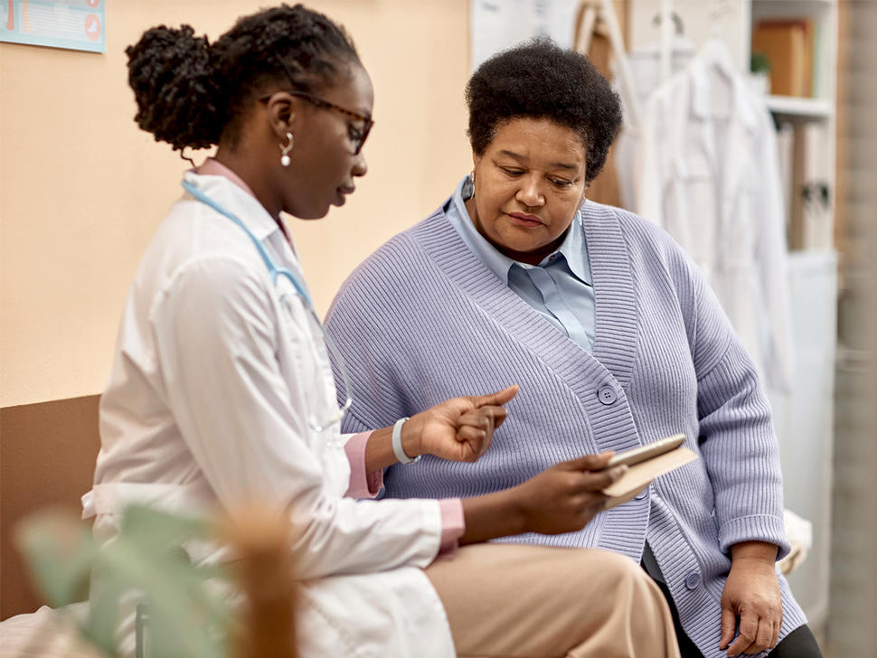 A medical doctor and cancer patient looking at information on a tablet computer.