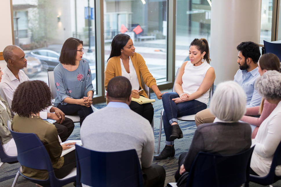 People sitting in a circle listening to each other talk.