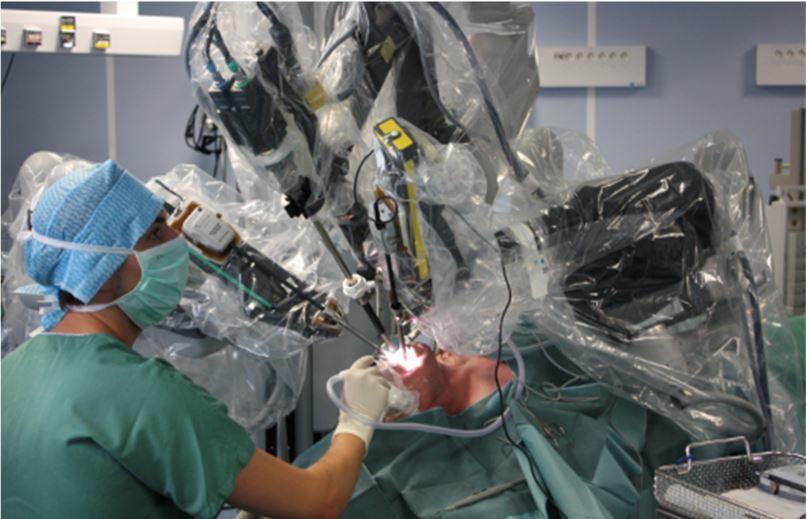 A photograph of robotic surgery being performed on a male patient.