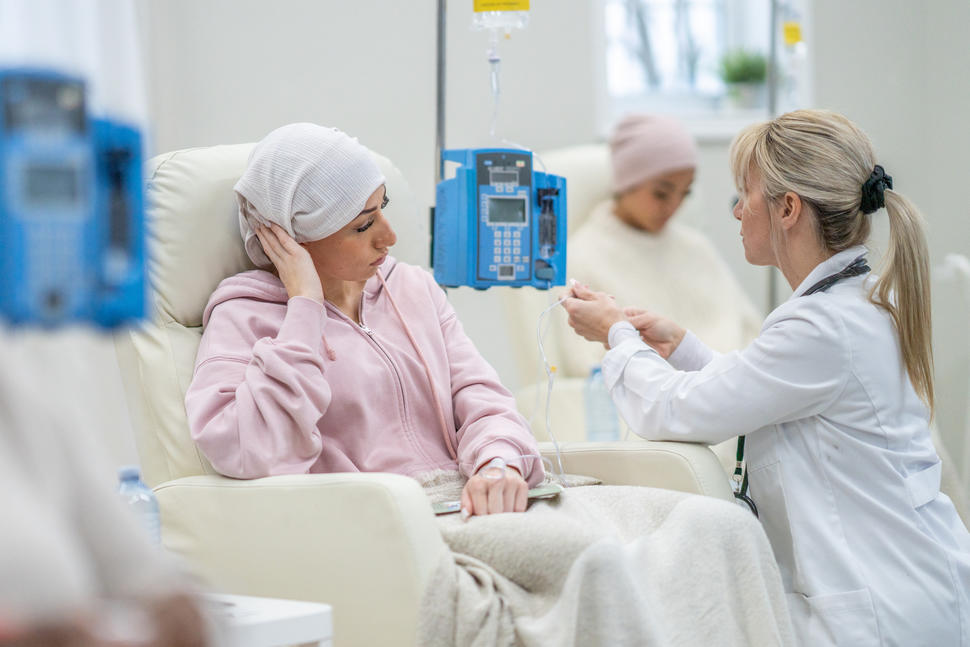Young adult cancer patient talking with doctor