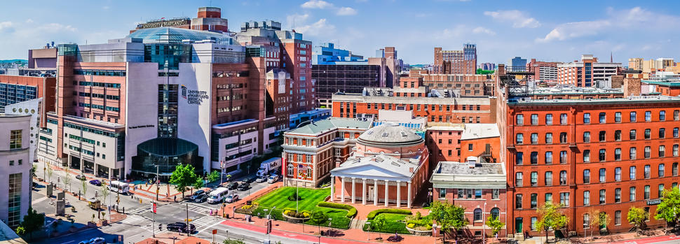University of Maryland Greenebaum Cancer Center complex with surrounding city buildings and streets under a clear sky.