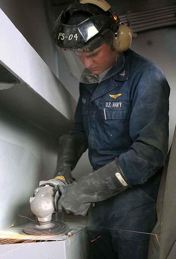Man grinding down the surface of a storage box