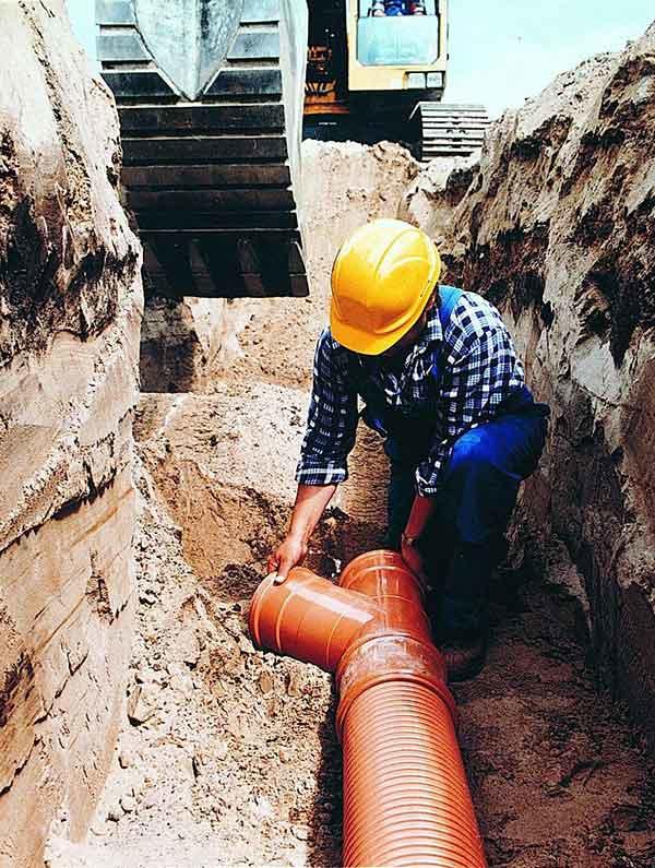 Man laying pipe made of polyvinyl chloride, or PVC 