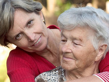 Adult daughter hugging mother.