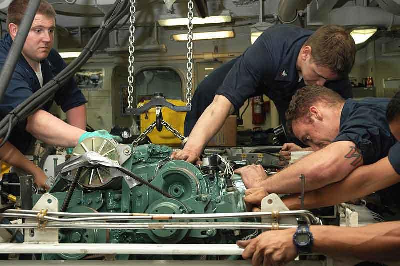 Hombres reparando un motor.