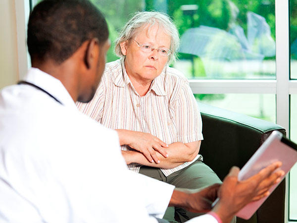 Doctor consulting with elderly patient in medical office