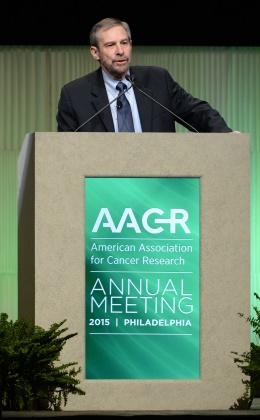 Dr. Lowy speaks from an AACR lectern