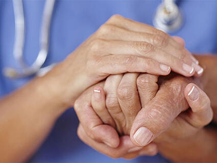 Close up shot of a doctor holding patient's hand