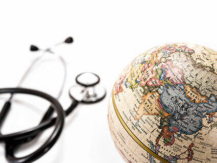 Photo of a stethoscope next to a globe