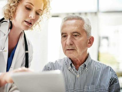 A medical professional and patient reviewing information on paper. 