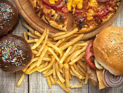 Image of high fat foods including donuts, french fries, cheeseburger, and pizza.