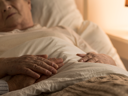 A sick man in a hospital bed.