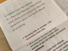 A photo of a newspaper page with text that includes a court ordered statement from major tobacco companies along statistics abou the negative health impacts of smoking.
