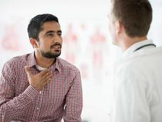 A person having a conversation with a doctor in a medical office.