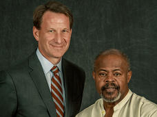 Dr. Sharpless and a former patient, Mike together in a photo studio with a dark backdrop