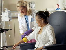 A medical professional bandaging a patient receiving IV chemotherapy.