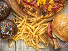 Image of high fat foods including donuts, french fries, cheeseburger, and pizza.