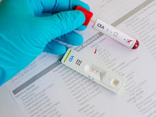 Gloved hand holding a test tube.