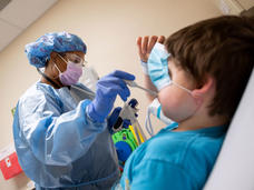 A nurse at St. Jude checking a boy's temperature.