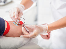 An image of a blood being collected into a tube from a male patient.