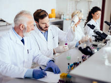Mixed age range team of scientists in research laboratory conducting science experiments.